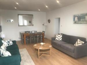 a living room with two couches and a table at Beachside Mews in Broadstairs