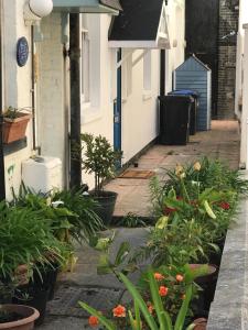 an alley with plants in pots in front of a house at Beachside Mews in Broadstairs