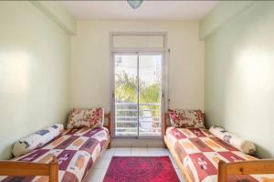 2 Betten in einem Zimmer mit Fenster in der Unterkunft Appartement confortable residence koutoubia quartier nassim casablanca in Casablanca