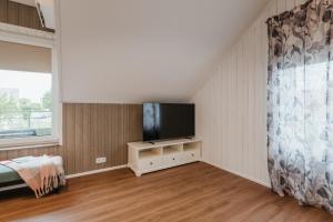 a living room with a flat screen tv and a bed at Lapmanni Studios in Haapsalu