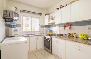 a kitchen with white cabinets and a stove top oven at Appartement confortable residence koutoubia quartier nassim casablanca in Casablanca