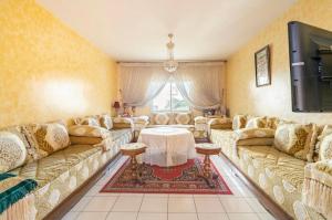 ein großes Wohnzimmer mit Sofas und einem TV in der Unterkunft Appartement confortable residence koutoubia quartier nassim casablanca in Casablanca