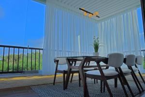 a dining room with a table and chairs and a balcony at AKS Home appart 1 - CABONEGRO in Cabo Negro
