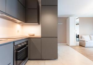 a kitchen with black cabinets and a stove at Nowohucka Apartament in Krakow