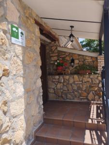 een stenen huis met een stenen muur en een trap bij Haza Del Puente in Riópar