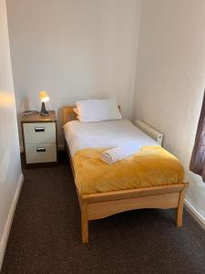 a small bedroom with a bed and a night stand at Superb Lime Guest House in Shildon