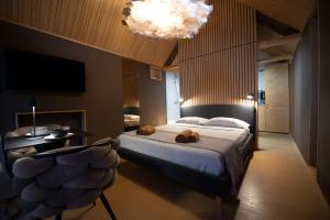 a bedroom with a bed and a chandelier at Moon - Tiny house from Callin Wines in Sežana
