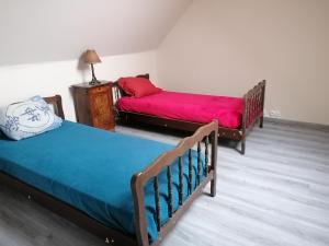1 dormitorio con 2 camas y manta roja en Maison où il fait bon se reposer en Onzain
