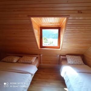 two beds in a room with a window at Bujtina Albjoni in Valbonë