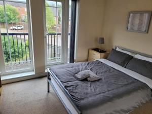 1 dormitorio con 1 cama y 2 ventanas grandes en TenPickering Place en Mánchester