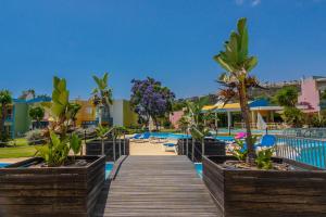 eine Promenade, die zum Pool in einem Resort führt in der Unterkunft Apartamentos Orada - Marina De Albufeira in Albufeira