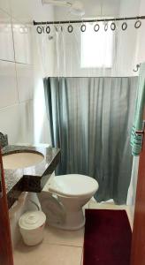 y baño con aseo, lavabo y ducha. en Apartamento novo 450 mt da praia Ingleses, en Florianópolis