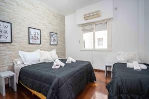 Un dormitorio con dos camas con toallas encima. en Buenos Aires Peatonal AV.Corrientes, en Buenos Aires