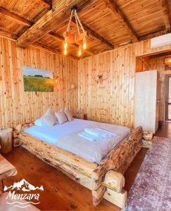 a bed in a wooden room with a wooden ceiling at Menzara Hotel & Restaurant in Sapanca
