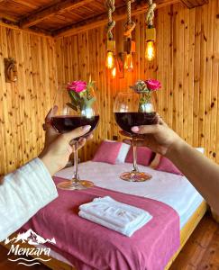 a person holding up two glasses of wine at Menzara Hotel & Restaurant in Sapanca