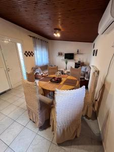 uma sala de jantar com uma mesa de madeira e cadeiras em Traditional villa Palio em PalaiónTsiflíkion