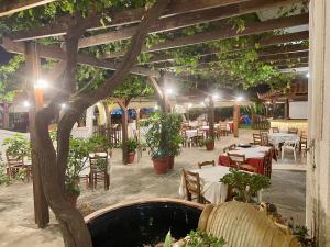 a restaurant with tables and a tree in the middle at Lefka in Kolymvari