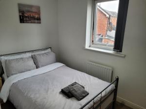 sypialnia z białym łóżkiem i oknem w obiekcie TenPickering Place w Manchesterze