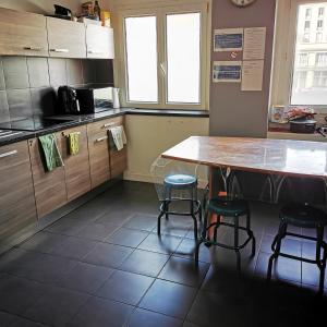 a kitchen with a table and two stools at Résidence Zola in Le Havre