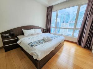1 dormitorio con 1 cama y ventana grande en Crest Residence Klcc Bukit Bintang by Sarah's Lodge, en Kuala Lumpur