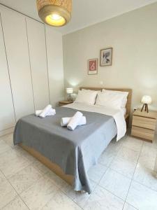 a bedroom with a large bed with two towels on it at Gravity Ialysos Scandi Suite in Ialyssos