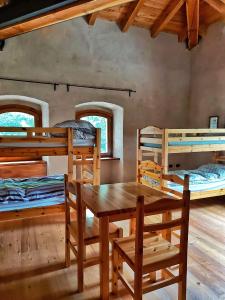 a room with a table and chairs and bunk beds at Forte di Machaby in Arnad