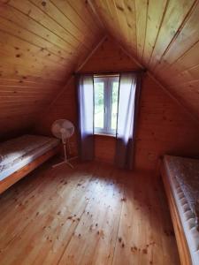 an attic room with two beds and a window at Domek na Górce in Rabe