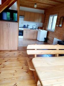 uma cozinha com pisos de madeira e mesas de madeira num camarote em Domek na Górce em Rabe