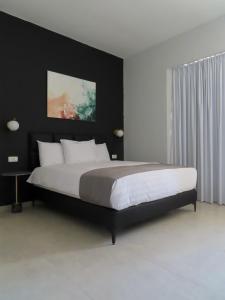 een slaapkamer met een groot bed met een zwart hoofdeinde bij White Moon Inn in Jeruzalem