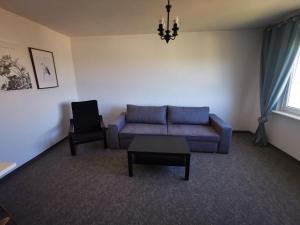 sala de estar con sofá azul y silla en Mieszkanie Obłuże 11 piętro en Gdynia