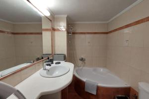 a bathroom with a sink and a bath tub at Avli House in Heraklio