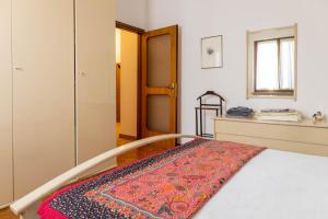 Un dormitorio con una cama con una alfombra. en Casa Mercedes, en Desenzano del Garda