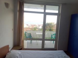 a bedroom with a large glass door to a balcony at Villa Poliana in Sveti Vlas