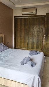 Un dormitorio con una cama blanca con toallas. en Villa de luxe residence tamaris marina 6 piscines jardin parking, en Saidia 