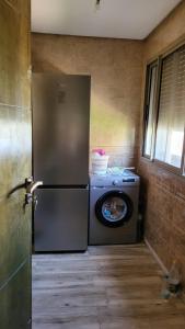 eine Küche mit einem Kühlschrank und einer Waschmaschine in der Unterkunft Villa de luxe residence tamaris marina 6 piscines jardin parking in Saidia 
