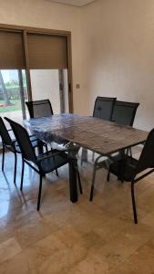 een grote houten tafel met stoelen eromheen bij Villa de luxe residence tamaris marina 6 piscines jardin parking in Saidia 