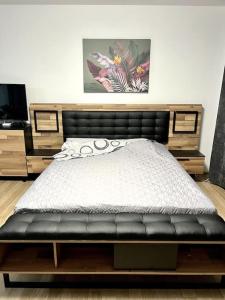 ein Schlafzimmer mit einem Bett mit einem schwarzen Lederbettrahmen in der Unterkunft Casa del Sole - beautiful studio in Varna Bulgaria in Warna