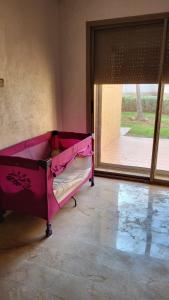 a pink bed in a room with a large window at Villa de luxe residence tamaris marina 6 piscines jardin parking in Saidia 