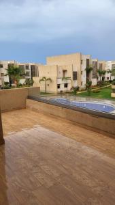 eine leere Terrasse mit Pool in einem Gebäude in der Unterkunft Villa de luxe residence tamaris marina 6 piscines jardin parking in Saidia 