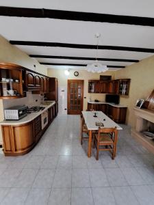 a large kitchen with wooden cabinets and a table at Stanze Del Corso in San Marco dei Cavoti