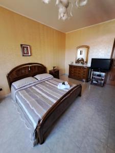 a bedroom with a large bed and a television at Stanze Del Corso in San Marco dei Cavoti