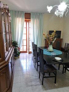 a dining room with a table and chairs with a vase of flowers at Stanze Del Corso in San Marco dei Cavoti