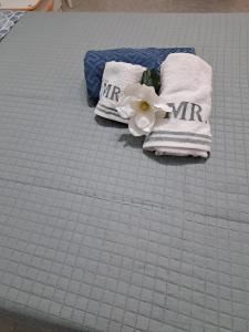 a bed with two towels and a flower on it at Stanze Del Corso in San Marco dei Cavoti
