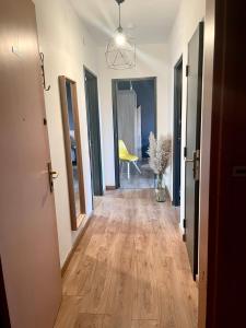 przedpokój apartamentu z drewnianą podłogą i żółtym krzesłem w obiekcie - Le refuge Colmarien - 5 personnes w mieście Colmar