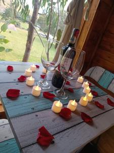 una mesa con velas y una botella de vino y copas en Casa en el Árbol Guatavita en Guatavita