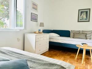 a bedroom with two beds and a table and a window at Blue Horizon in Novi Vinodolski