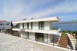 une maison blanche avec vue sur l'eau dans l'établissement Villa Brac, à Splitska