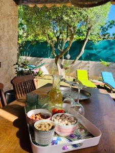 een tafel met een dienblad met eten en wijnglazen bij MAISON PROVENCALE in Six-Fours-les-Plages