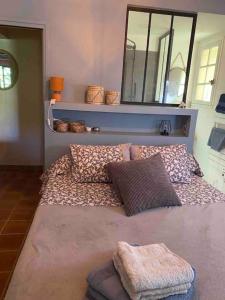 een kamer met een bed met kussens en een spiegel bij MAISON PROVENCALE in Six-Fours-les-Plages