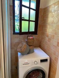 een wasmachine in een badkamer met een raam bij MAISON PROVENCALE in Six-Fours-les-Plages